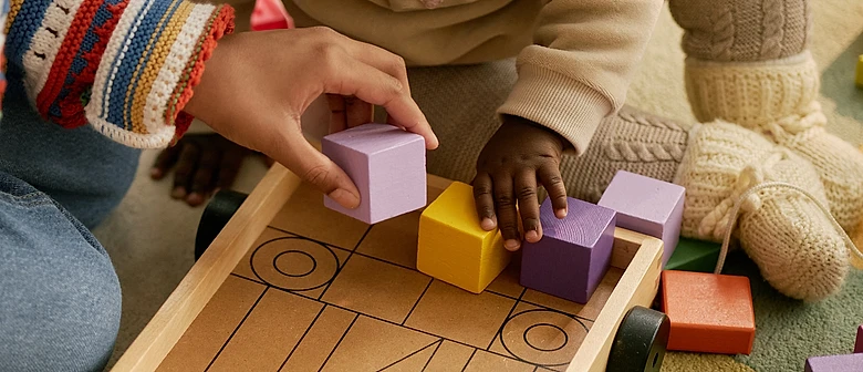Criança e adulto brincando com blocos coloridos de montar